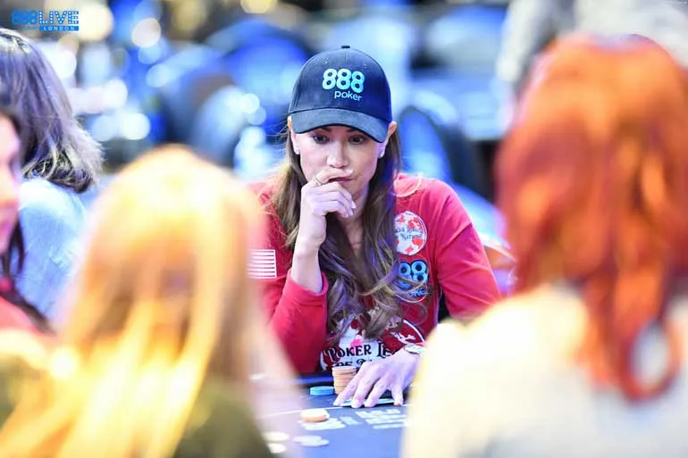 Mulher com boné da 888poker à mesa