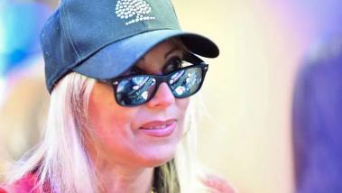Mulher de óculos e boné jogando poker