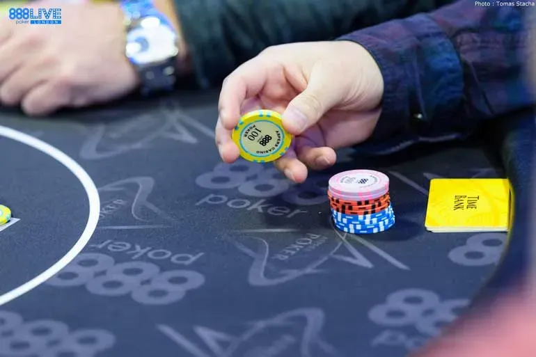 Mão segurando uma ficha de poker