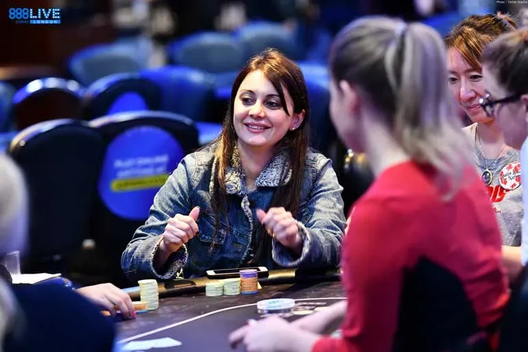 Mulher feliz à mesa jogando poker